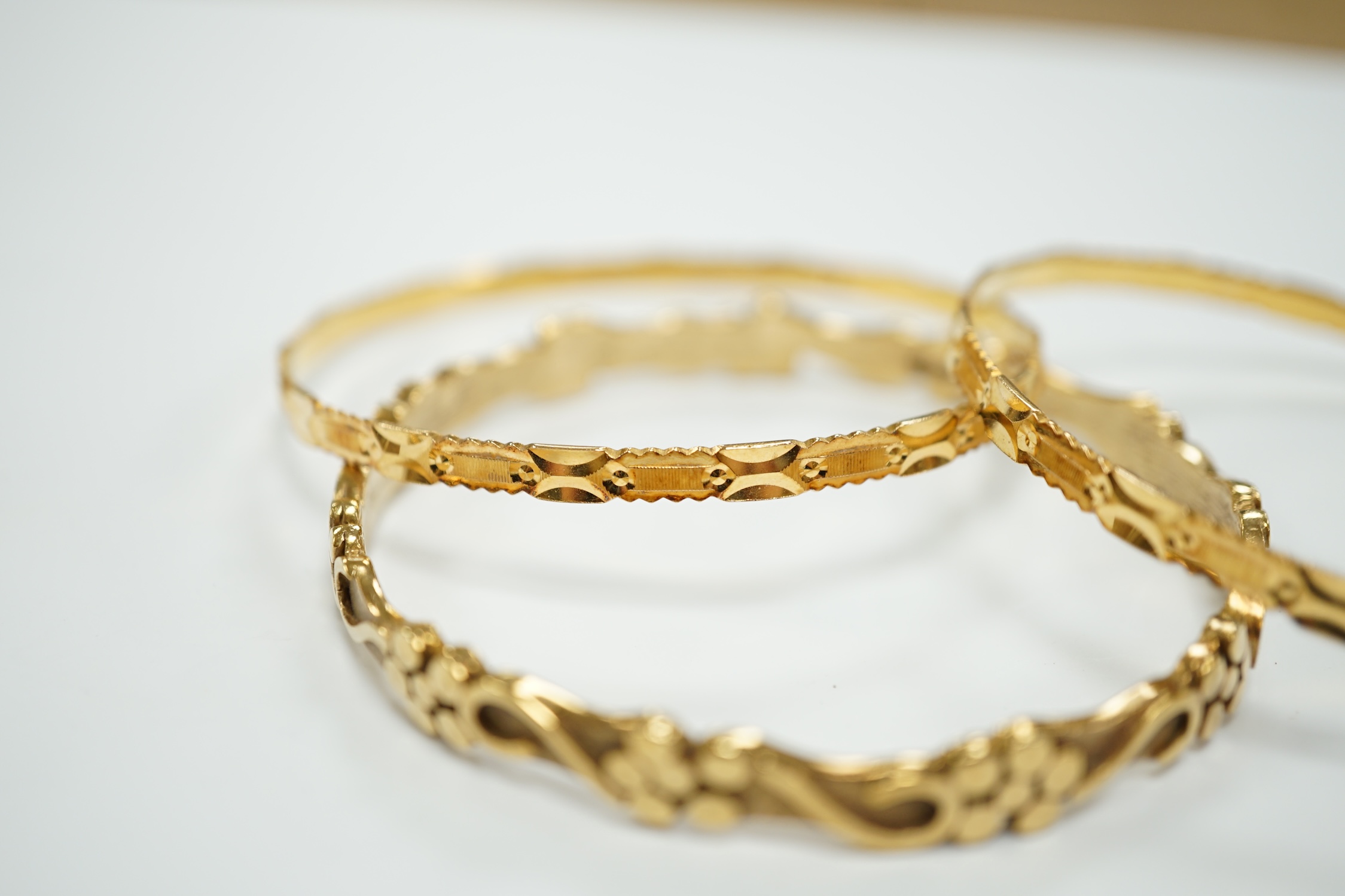 Two 22k bangles, 19.6 grams and a 9ct gold bangle, 20.6 grams.